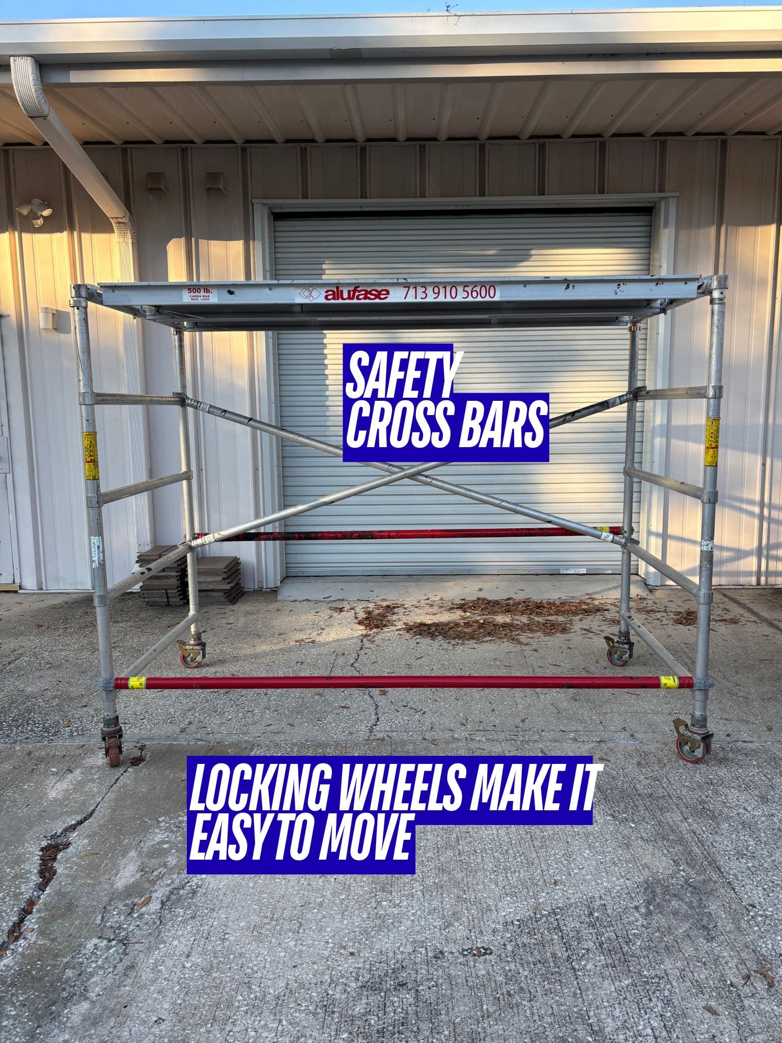 Mobile aluminum scaffolding unit with safety cross bars and locking wheels for easy movement.